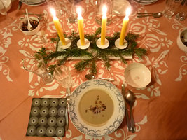 weihnachtlich gedeckter Tisch mit Kerzen und Selleriecremesuppe